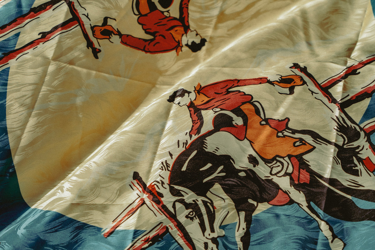 Vintage Rockmount Ranch Wear Bronc Silk Scarf in blue with western jacquard silk pattern, 36 inch square