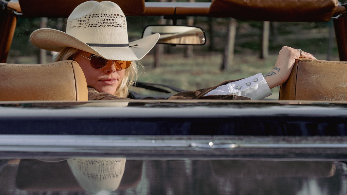 Vintage western wear cowboy shirt with fringe and embroidered floral details, worn by a woman in a car